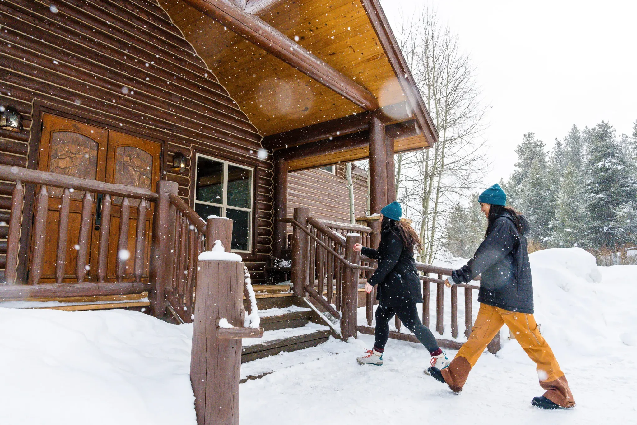 snowmobile tour guests entering lodge on a snowy day